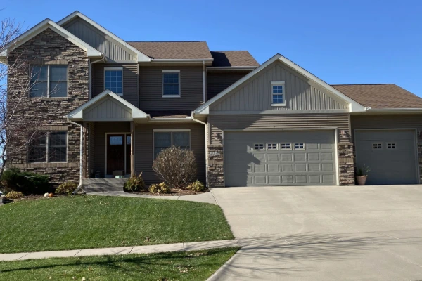 New shingle roof installed on a two-story stone and siding home in eastern Iowa